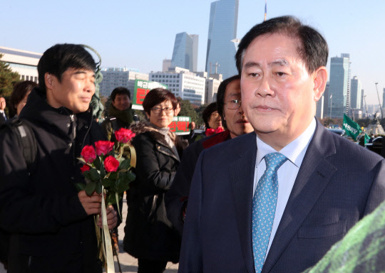 <탄핵표결> 최경환 '외면'      (서울=연합뉴스) 배재만 기자 = 새누리당 최경환 의원이 9일 오후 국회 본회의장에서 열린 박근혜 대통령의 탄핵소추안에 대한 표결을 위해 입장하다 환경운동연합 등 시민단체 회원들이 전달하는 '탄핵찬성 촉구' 꽃을 외면하고 있다. 2016.12.9      scoop@yna.co.kr  (끝)